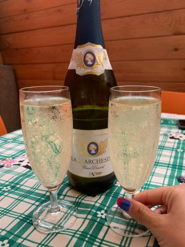a bottle of champagne and two glasses on a table at CHALET IL GELSOMINO DELL'ETNA in Giarre