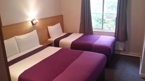 ロンドンにあるアリヴァ ホテルのベッド2台と窓が備わるホテルルームです。