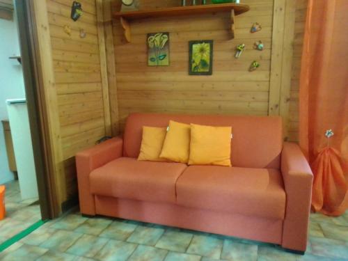 a brown couch with yellow pillows in a room at CHALET IL GELSOMINO DELL'ETNA in Giarre
