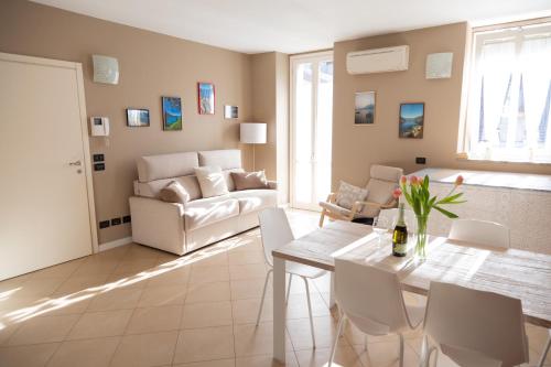 a living room with a white couch and a table at Bellagio Love apartment Pool Near lake Free parking in Bellagio