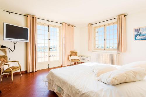 une chambre avec un lit et une télévision au mur dans l'établissement Villa Les Feuillets VI4250 by Riviera Holiday Hom, à Roquefort-les-Pins