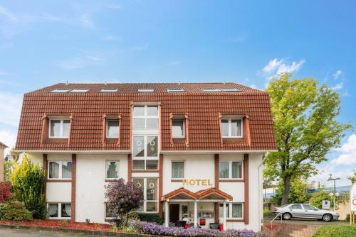 un hotel con techo rojo en Arador-City Hotel en Bad Oeynhausen