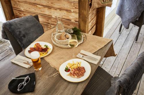 a table with two plates of food and a glass of beer at ROBINSON Landskron in Landskron