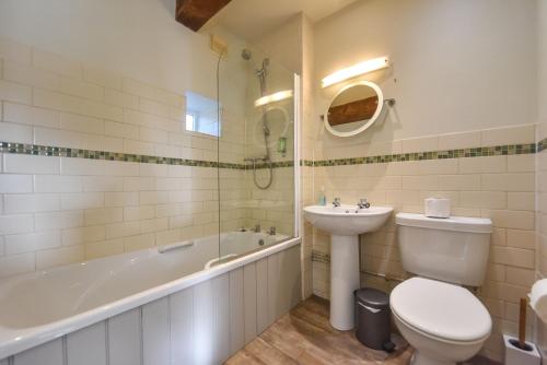 a bathroom with a toilet and a sink and a bath tub at Church Farm Holiday Cottages - Winnets Cottage in Ashbourne