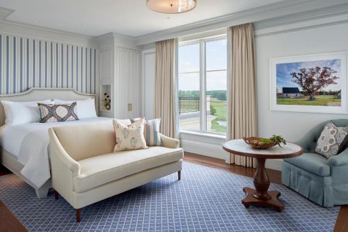 a bedroom with a bed and a chair and a window at Keswick Hall in Charlottesville