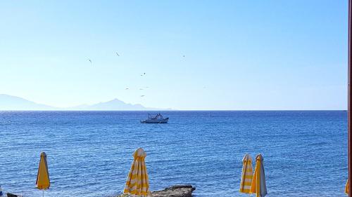 a boat in the middle of the ocean with umbrellas at Silver Beach Hotel in Kardamaina