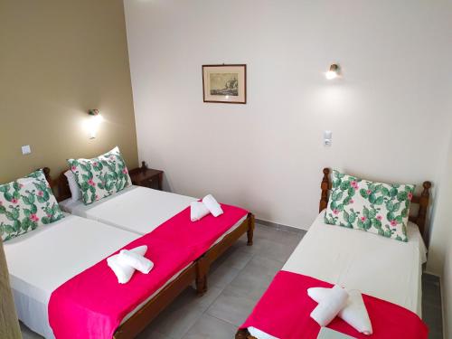 two beds in a room with red and white sheets at Silver Beach Hotel in Kardamaina