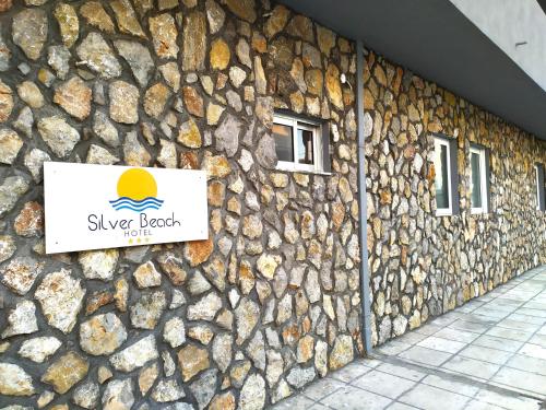 a stone building with a sign on it at Silver Beach Hotel in Kardamaina