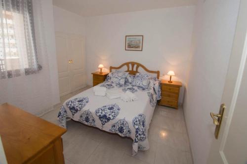 1 dormitorio con 1 cama azul y blanca y 2 mesitas de noche en Topacio i 25c, en Calpe