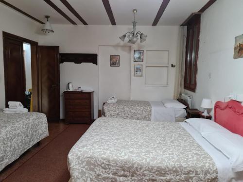 a hotel room with two beds and a dresser at Alloggi alla Scala del Bovolo in Venice