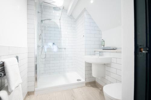 a white bathroom with a shower and a sink at The Pine Marten by Innkeeper's Collection in Harrogate