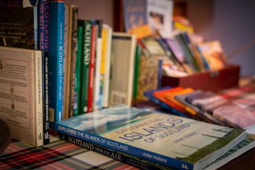 a pile of books sitting on a table at The Beeches Studio, Highlands of Scotland in Newtonmore