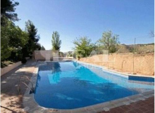 a large blue swimming pool in a yard at Apartamentos Serrallo, Parking gratuito y cocina, Alhambra y playa in Granada
