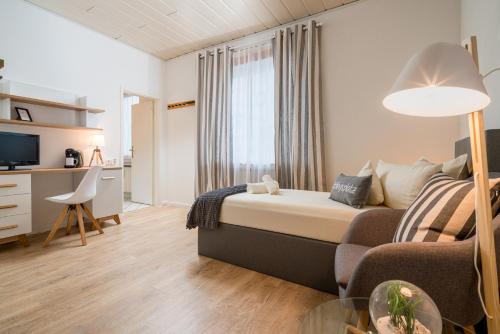 a bedroom with a bed and a couch and a table at Arador-City Hotel in Bad Oeynhausen