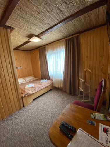 a room with a bed and a desk and a table at Guest house Shulc in Mizhhirʼʼya