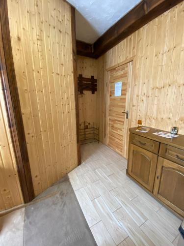 a room with wooden walls and a kitchen with a door at Guest house Shulc in Mizhhirʼʼya