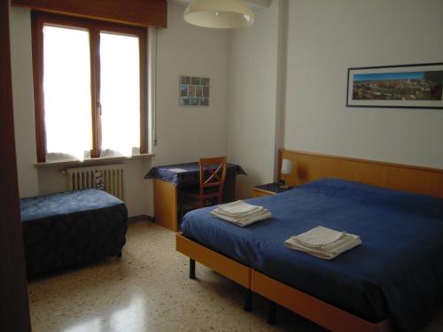 ヴェローナにあるIl Lorì di Alessandraのベッドルーム1室(ベッド2台、タオル付)