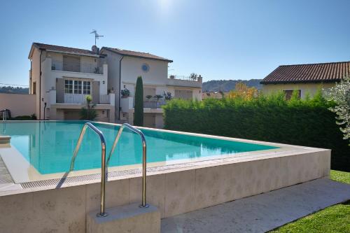 ein Pool vor einem Haus in der Unterkunft ApartmentsGarda - Corte dei Molini in Garda