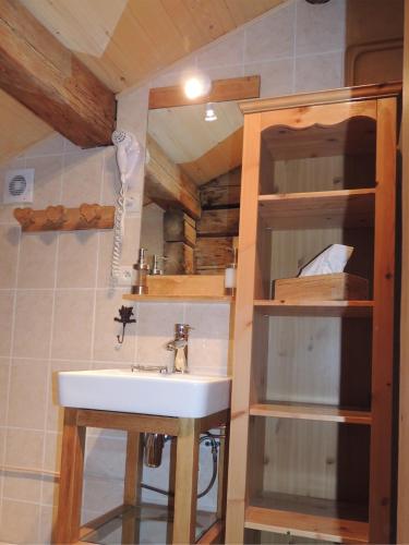 La salle de bains est pourvue d'un lavabo et d'étagères. dans l'établissement La Bournerie, au Grand-Bornand
