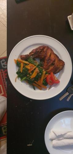 a plate of food with meat and vegetables on a table at Walabi Mara Hotel in Narok