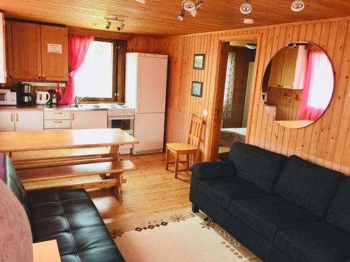 un soggiorno con divano e una cucina di Ullan Kylä a Kittilä