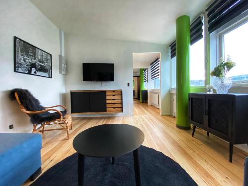 a living room with a tv and a chair at Broncks Apartment 4 - Modern 1-Bedroom in the Heart of Tórshavn in Tórshavn
