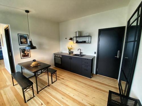 a kitchen with a table and a sink at Broncks Apartment 4 - Modern 1-Bedroom in the Heart of Tórshavn in Tórshavn