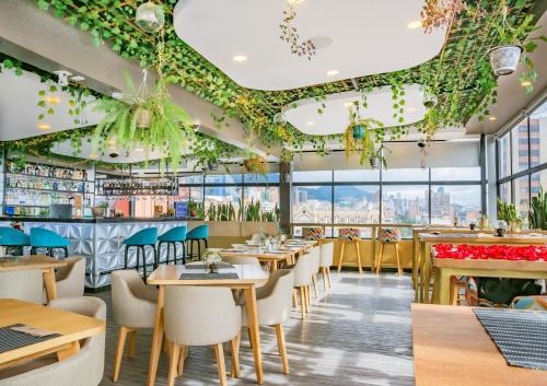 a restaurant with tables and chairs and windows at Hotel Express 53 in Bogotá