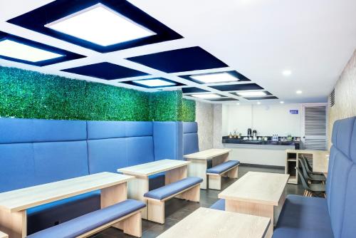 a restaurant with tables and benches and a kitchen at Hotel Express 53 in Bogotá
