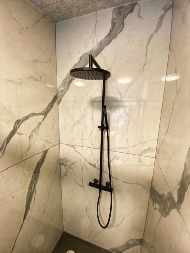a shower with a black shower head in a bathroom at Broncks Apartment 2 - Modern 2-Bedroom in the Heart of Tórshavn in Tórshavn