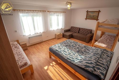 sala de estar con cama y sofá en Wesołówka - dom do wynajęcia, en Przerośl