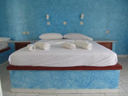 a large bed with white sheets and pillows on it at Afentoulis Studios 2 in Kefalos