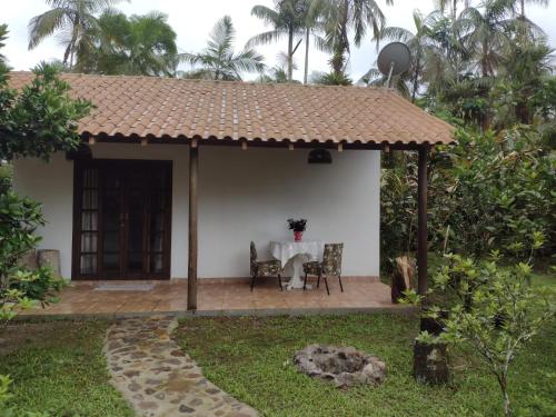 a patio with a table in a house at Armazém do Porto, Chalé Azaléia in Morretes