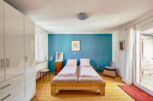 een slaapkamer met 2 bedden en een blauwe muur bij Ferienhaus CASA PI mit Garten bis 4 Erw. 2 Kinder in Forst