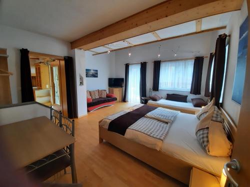 フラタッハにあるFerienwohnung am Bauernhof Zechner Heidiのベッドルーム(大型ベッド1台付)、リビングルームが備わります。