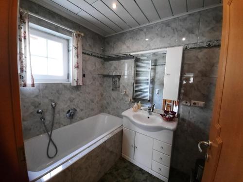 a bathroom with a bath tub and a sink at Ferienwohnung am Bauernhof Zechner Heidi in Flattach