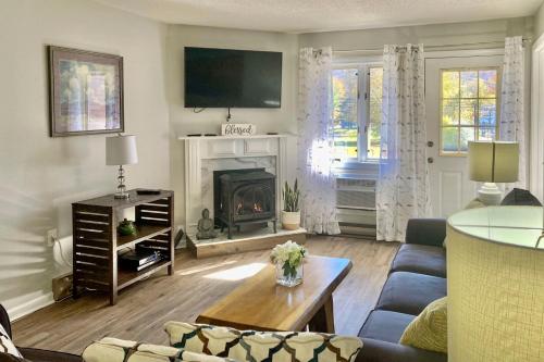 a living room with a couch and a fireplace at Hike, Ski, Explore Lincoln Condo with Pool Access in Lincoln