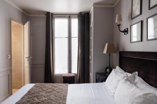 a bedroom with a large bed and a window at Hotel Saint-Louis Pigalle in Paris