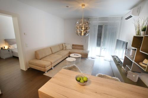 uma sala de estar com um sofá e uma mesa em 25h SPA-Residenz POOLs IN & OUT, private Garden & Beach em Neusiedl am See