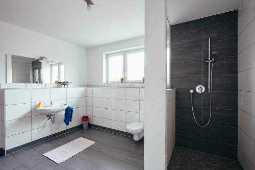 a bathroom with a shower and a toilet and a sink at Ferienhaus Sommerweide 160qm bis 10P in Haßloch