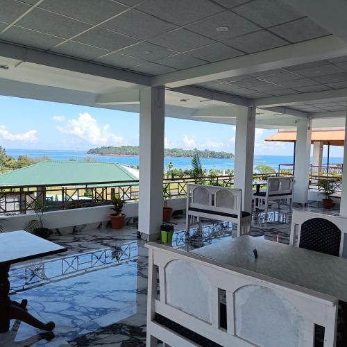 a view of the ocean from a restaurant with tables and chairs at Blue Bridge Homes in Port Blair