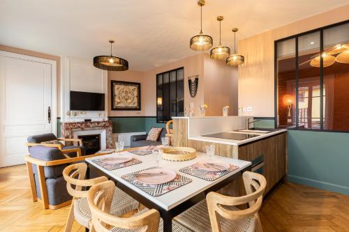 een keuken en een woonkamer met een tafel en stoelen bij Host inn Lyon - Hypercentre Vieux Lyon in Lyon