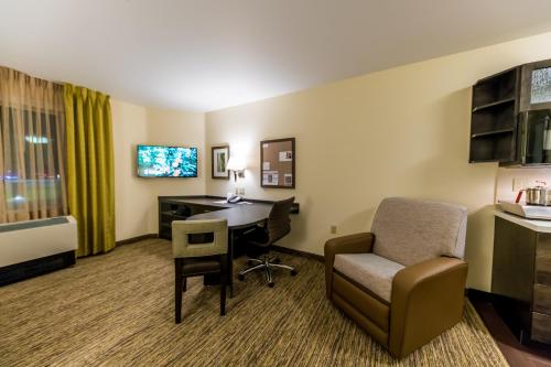 a hotel room with a desk and a chair at Candlewood Suites - Fairbanks by IHG in Fairbanks
