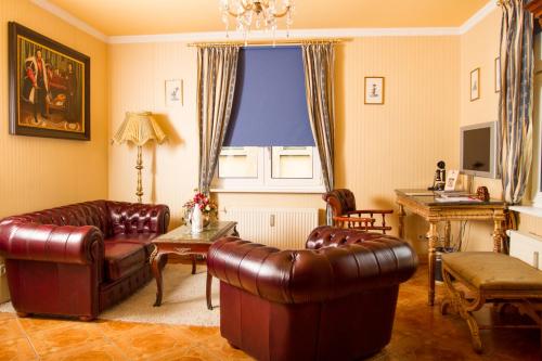 sala de estar con muebles de cuero y ventana en Hotel Don Giovanni, en Leipzig