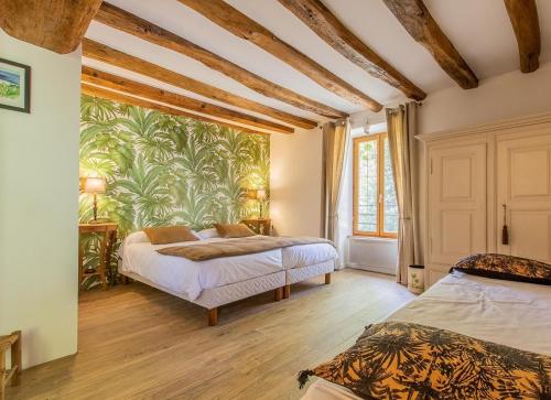 een slaapkamer met 2 bedden en een muurschildering bij Le Domaine de Moroges in Moroges