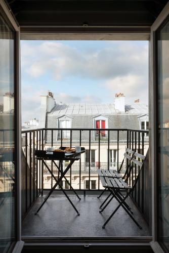 a balcony with a table and chairs and a view at Hotel Saint-Louis Pigalle in Paris