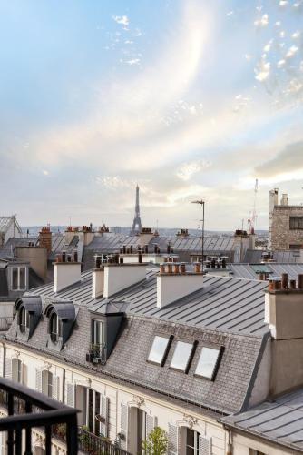 a view of roofs of buildings with the eiffel tower at Hotel Saint-Louis Pigalle in Paris