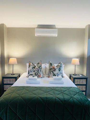 a bedroom with a green bed with two lamps at Rest at Lieben in Bloemfontein