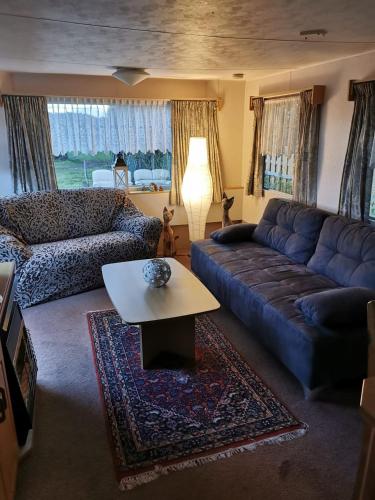 a living room with a couch and a coffee table at Herzfennerhof Mobilheim in Auw