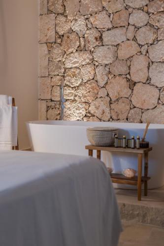 a stone wall in a bathroom with a table at Casas de San Pedro in Hita
